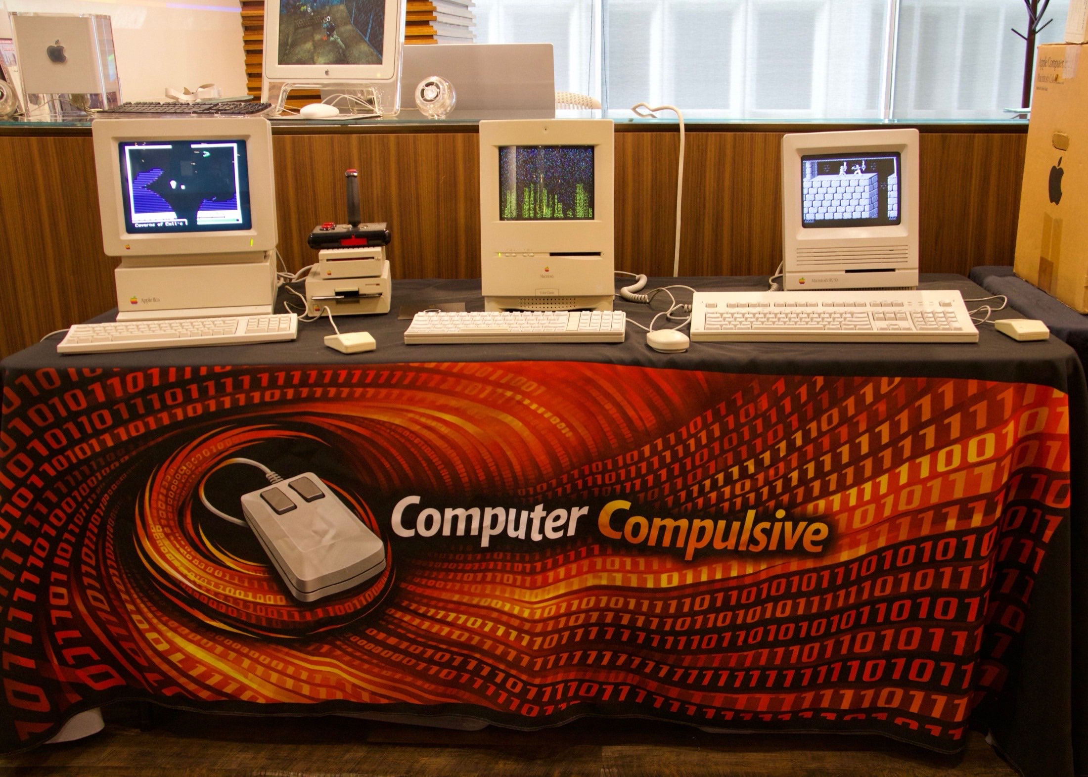 Three vintage Apple computers displayed on the Computer Compulsive booth table